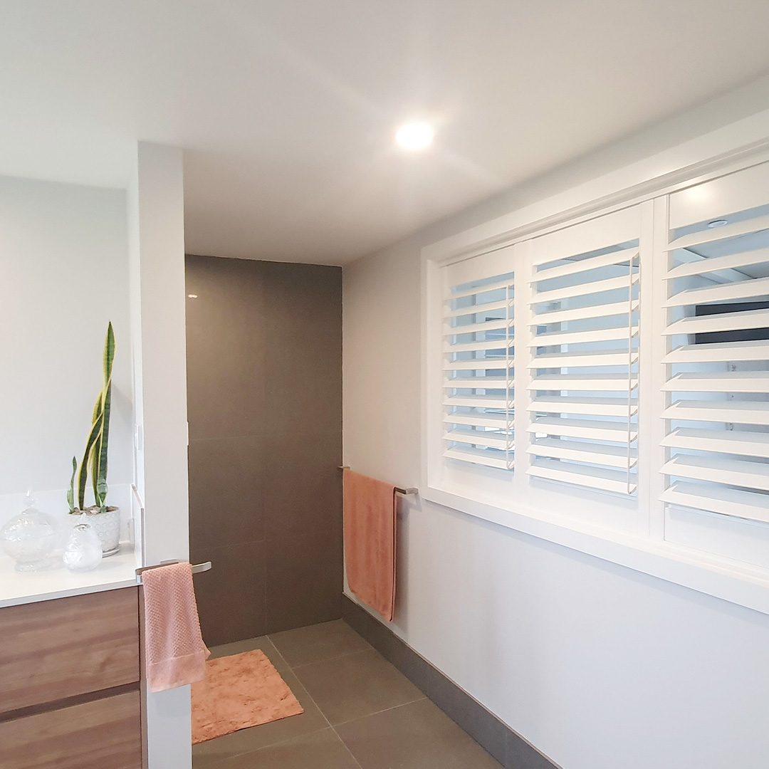 Detailed view of a white plantation shutter in a beautiful bathroom